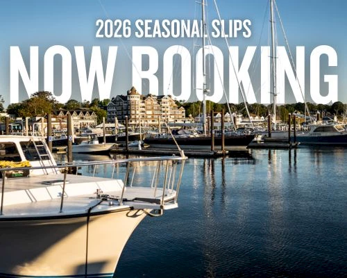 A marina with boats and sailboats docked, calm water reflecting the harbor, bold white text announcing “NOW BOOKING” and “2026 SEASONAL SLOTS.”